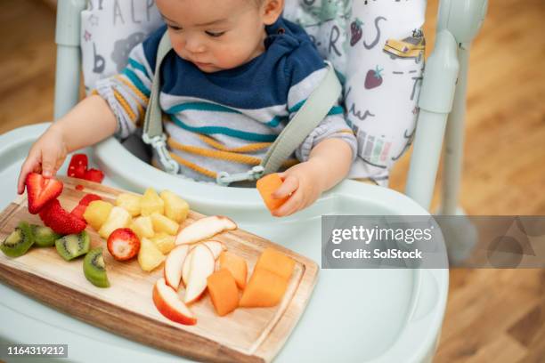 welche wähle ich aus? - baby spielt mit essen stock-fotos und bilder