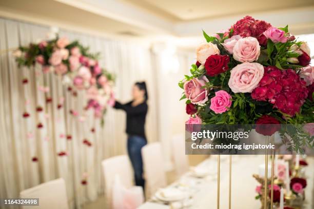 florista que termina sua parte do trabalho para o casamento no salão do banquete - wedding planner - fotografias e filmes do acervo