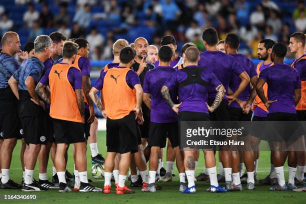 Pep Guardiola speaks to his players during a Manchester City press conference and training at the Nissan Stadium on July 26, 2019 in Yokohama,...