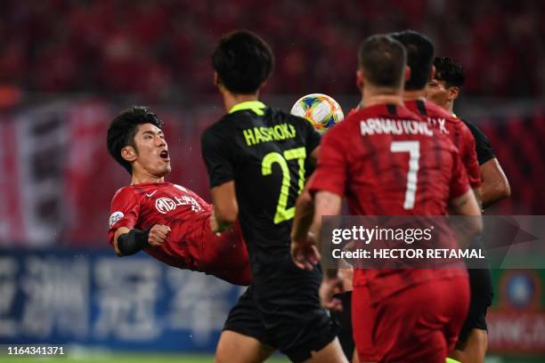 Shanghai SIPG's Lu Wenjun jumps to kick the ball in the match against Urawa Red Diamonds during their AFC Champions League quarter-final football...