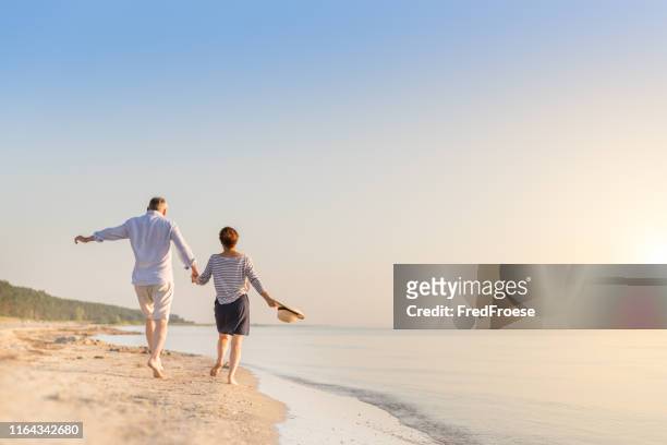 happy senior couple at beach - elderly couple holiday stock pictures, royalty-free photos & images