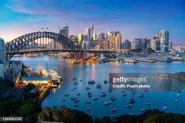 cityscape image of sydney, australia with harbor bridge and sydney skyline during sunset. vacation and travel in australia. - australia stock-fotos und bilder
