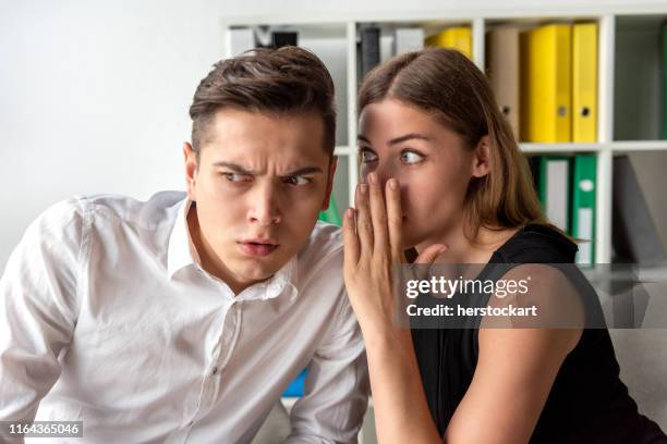 woman in office doing gossip - woman whisper to man stock pictures, royalty-free photos & images