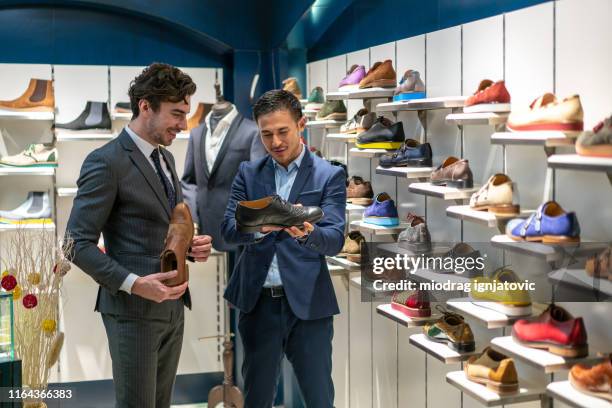 handsome shop assistants helping to customer - sapatos de homem imagens e fotografias de stock