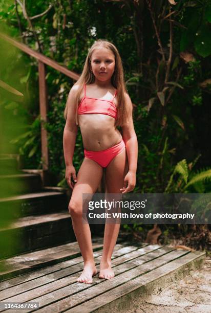 9 years old caucasian girl in swimwear on summer holidays sunbathing looking at camera - 8 9 years foto e immagini stock