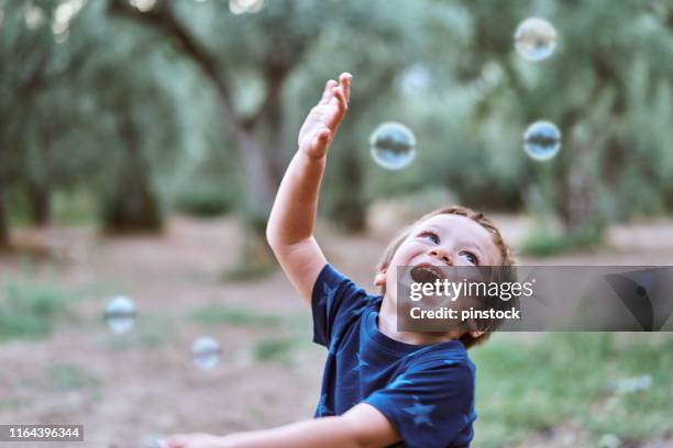 cute child playing with bubbles - ballkid stock pictures, royalty-free photos & images