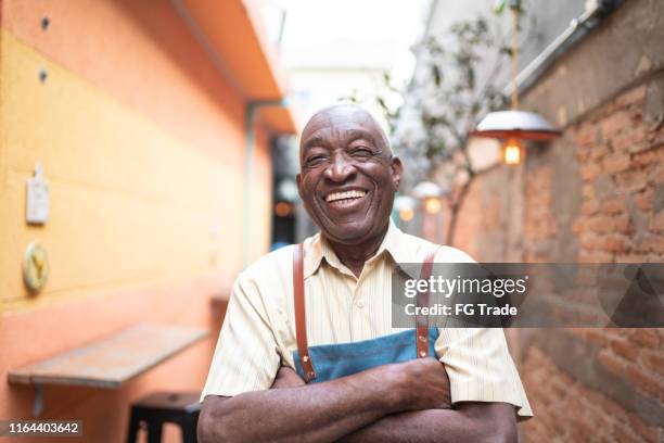 porträt eines lächelnden alten kellners, der in die kamera schaut - african american smiling stock-fotos und bilder