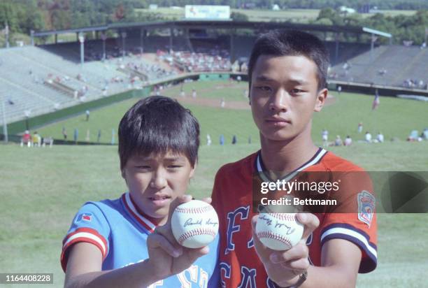 Hawaii's Ryan Morioka and Taiwan's Yu Chen-Lung hold up autographed baseballs signed by President Ronald Reagan presented to them earlier as they...