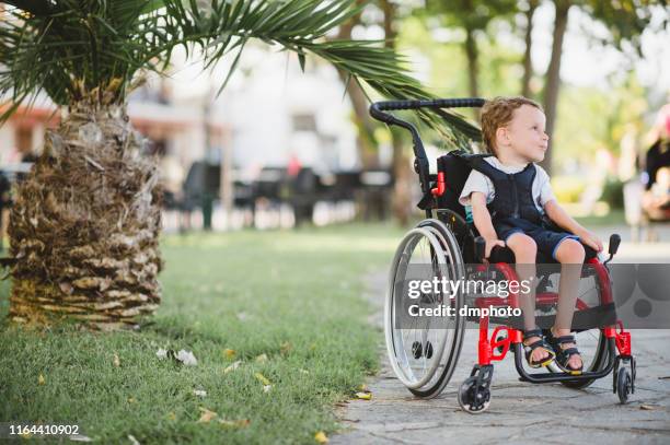 adorable disabled boy in wheelchair - atrophy stock pictures, royalty-free photos & images