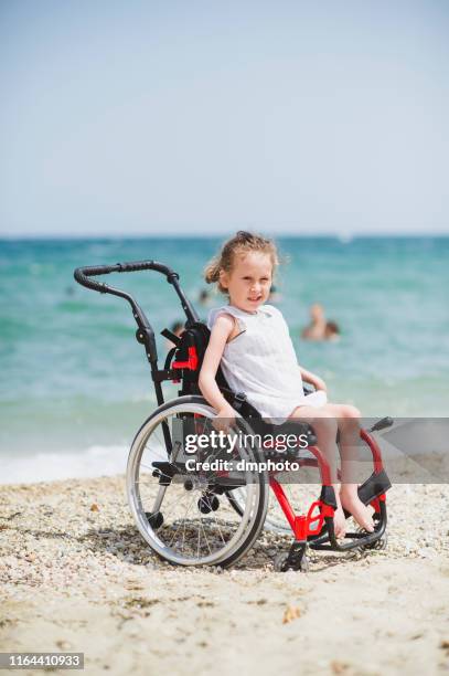 cute little girl on the wheelchair by the sea - atrophy stock pictures, royalty-free photos & images