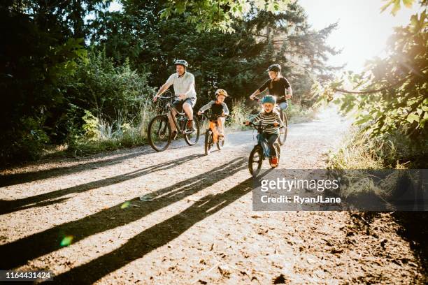 familien-mountainbike-fahren gemeinsam am sonnigen tag - freizeitaktivität stock-fotos und bilder