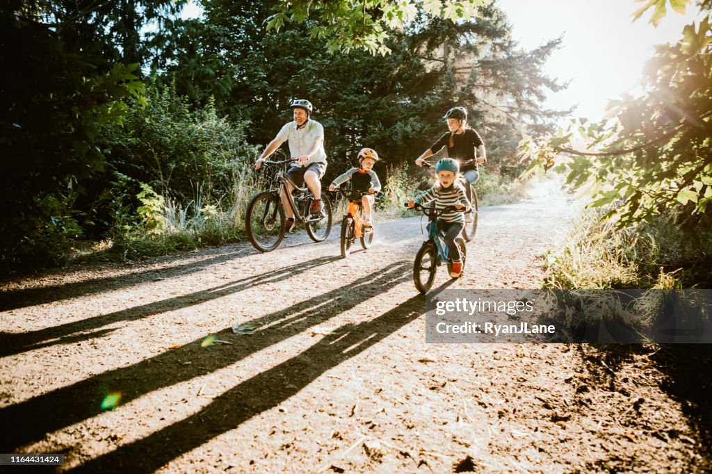 Familj mountainbike ridning tillsammans på solig dag