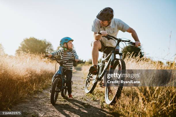 vater und tochter mountainbike fahren gemeinsam am sonnigen tag - bicycle daughter stock-fotos und bilder