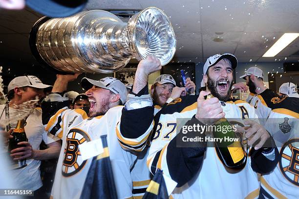 Brad Marchand and Patrice Bergeron of the Boston Bruins celebrate with the Stanley Cup in th locker room after Game Seven of the 2011 NHL Stanley Cup...