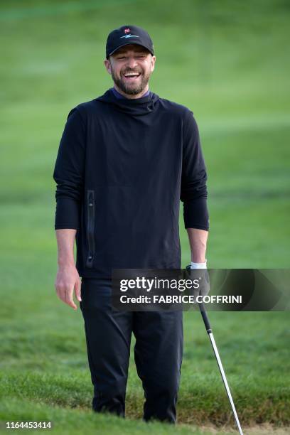 Singer-songwriter Justin Timberlake laughs as he plays during a pro-am tournament ahead of the PGA European Tour golf tournament Omega European...