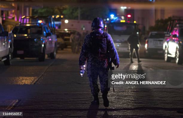 Mexican soldier stands guard outside a bar where 23 people were killed by a fire in Coatzacoalcos, Veracruz on August 28, 2019. - At least 23 people...