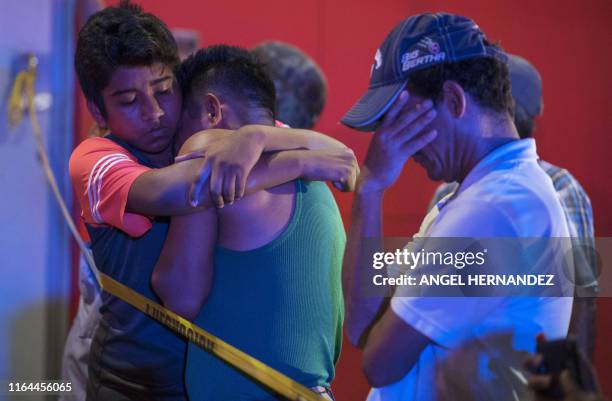 People react outside a bar where 23 people were killed by a fire in Coatzacoalcos, Veracruz on August 28, 2019. At least 23 people were killed and 13...