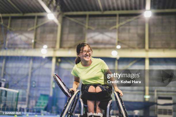 disabled female athlete playing wheel chair tennis - wheelchair tennis stockfoto's en -beelden