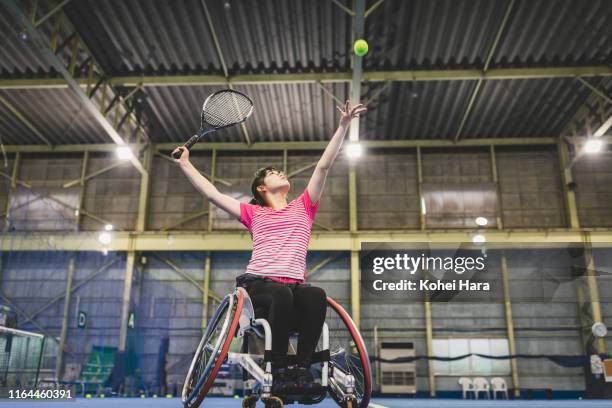 disabled female athletes serving during playing wheel chair tennis - japanese tennis photos et images de collection