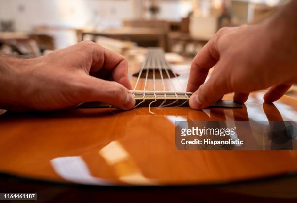 close-up on a man fixing a guitar - stringed instrument stock pictures, royalty-free photos & images