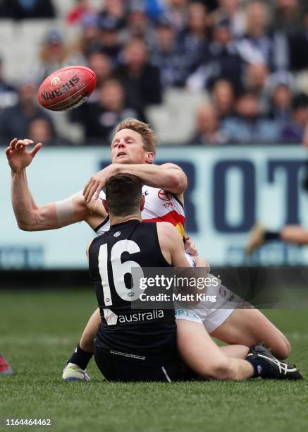 Rory Sloane of the Crows is tackled by Darcy Lang of the Blues during the round 19 AFL match between the Carlton Blues and the Adelaide Crows at...