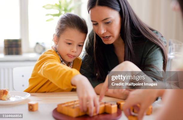 mother and daughter sitting at the table at home, playing board games. - granny flat stock pictures, royalty-free photos & images