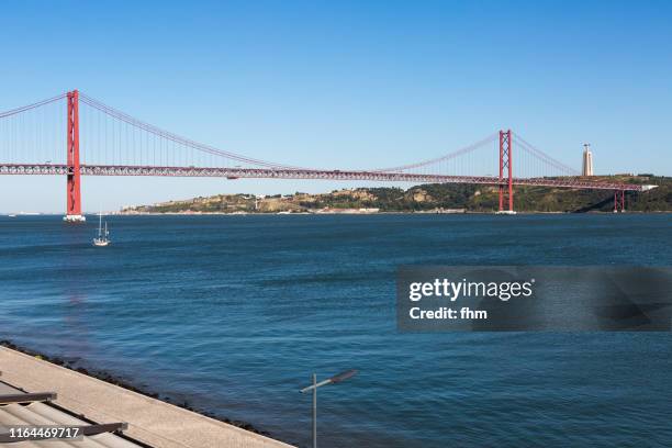 lisbon and ponte 25 de abril (bridge of april 25) - portugal - 25 de abril bridge stockfoto's en -beelden