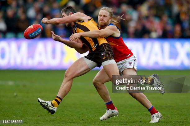 Daniel Rich of the Lions tackles Ricky Henderson of the Hawks during the round 19 AFL match between the Hawthorn Hawks and the Brisbane Lions at...