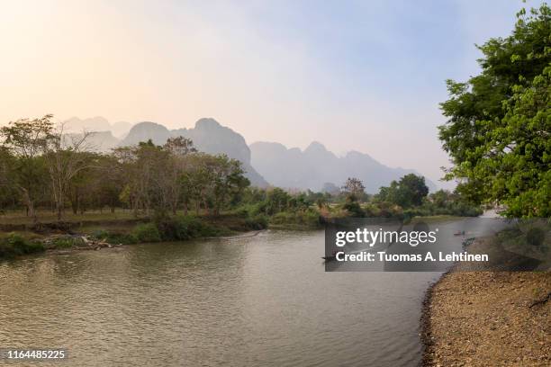 river and mountainous landscape in vang vieng - vang vieng stock-fotos und bilder