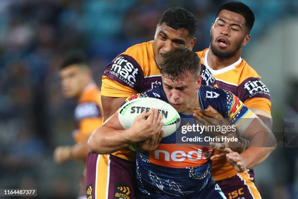 Jai Whitbread of the Titans is tackled during the round 19 match between the Gold Coast Titans and the Brisbane Broncos at Cbus Super Stadium on July...