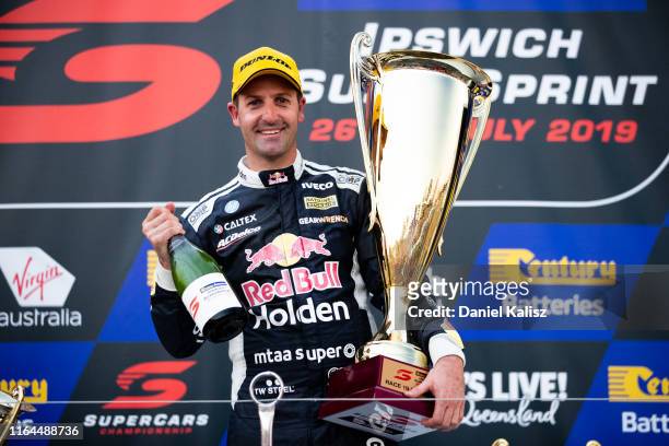 Jamie Whincup driver of the Red Bull Holden Racing Team Holden Commodore ZB celebrates on the podium during race 19 for the Ipswich SuperSprint on...