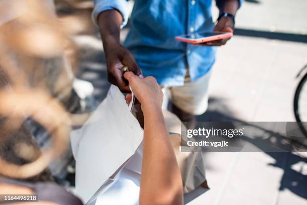 young african delivery man delivering package to customer - textile for delivery stock pictures, royalty-free photos & images