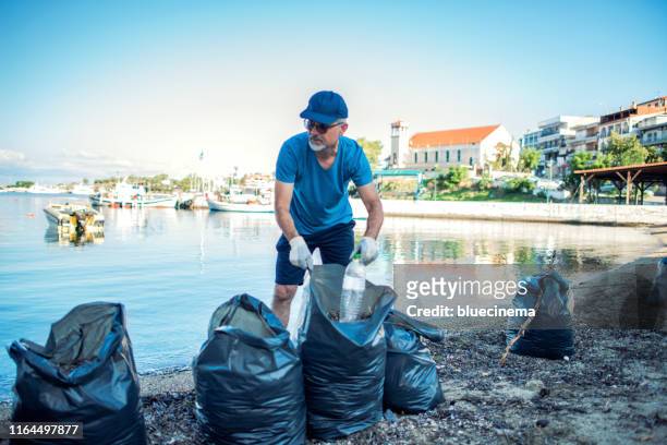 man cleaning beach - selfless stockfoto's en -beelden