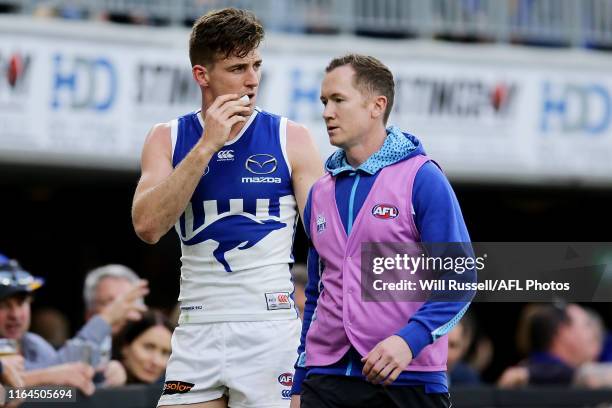 Shaun Atley of the Kangaroos is assisted off the field during the round 19 AFL match between the West Coast Eagles and the North Melbourne Kangaroos...