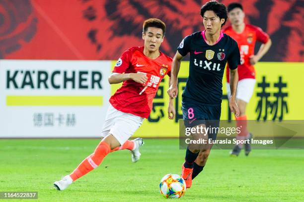 Shoma Doi of Kashima Antlers fights for the ball with Wei Shihao of Guangzhou Evergrande during the AFC Champions League quarter final match between...