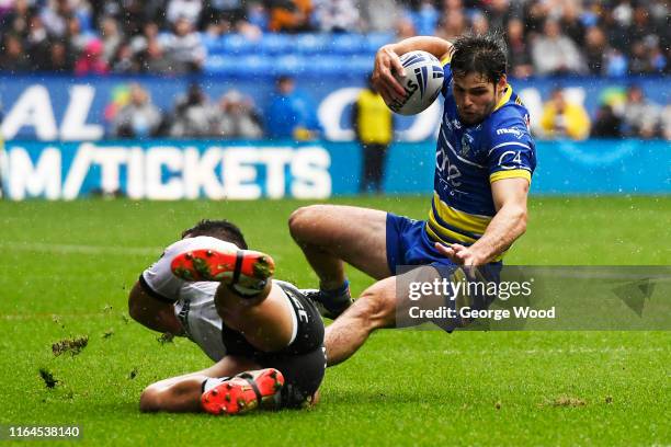 Jake Mamo of Warrington Wolves is tackled by Bureta Faraimo of Hull FC during the Coral Challenge Cup Semi-Final between Warrington Wolves and Hull...