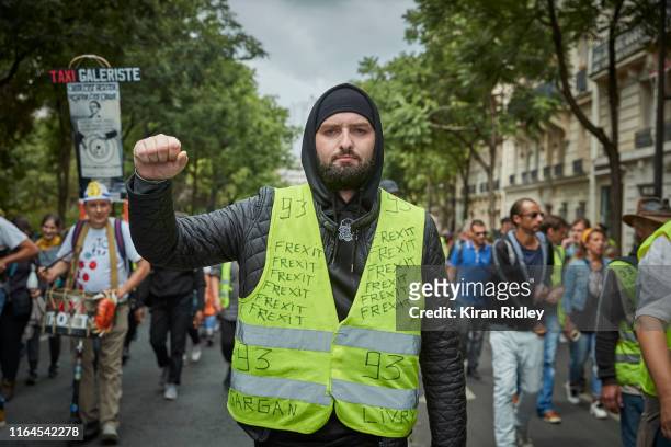 Gilets Jaunes protestors chant and sing against President Macron as they march through Paris during Act 37 of demonstrations on July 27, 2019 in...