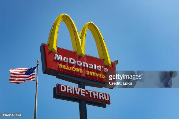 The sign for McDonald's drive in take-away restaurant and an American flag in the Silver Lake area of Los Angeles.
