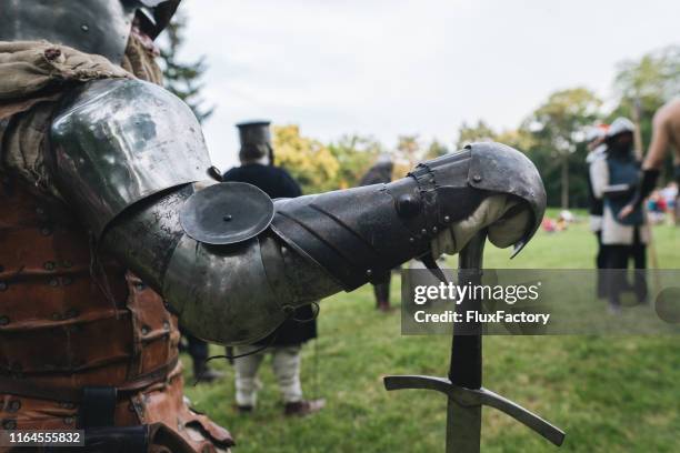 een ridder in het lichaam armor met een lange zwaard staande op een middeleeuws festival - renaissance stockfoto's en -beelden