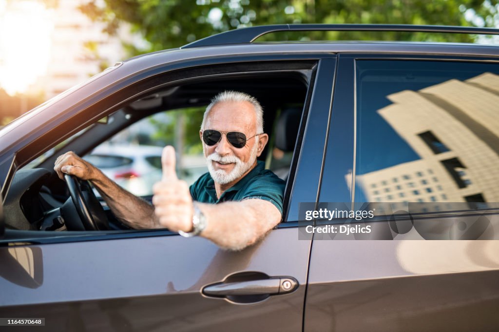 Senior man loves his new car.