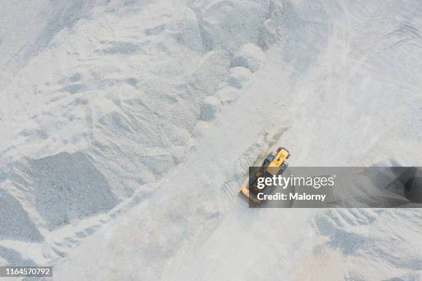 aerial view of digger at quarry. drone view. - baumaschine stock-fotos und bilder