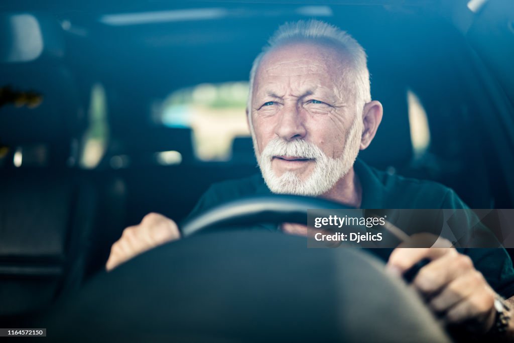Senior man having bad eye sight and making effort to see the road.