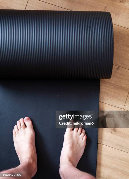 personal perspective of man standing on exercise mat - adult gymnast feet stock-fotos und bilder