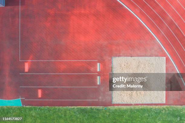 aerial view of sports venue with running track and long jump pit. - verspringen stockfoto's en -beelden