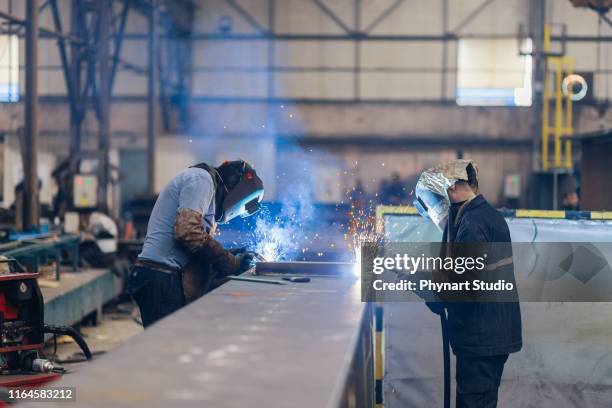 werknemers lassen deel in de fabriek - lasser stockfoto's en -beelden