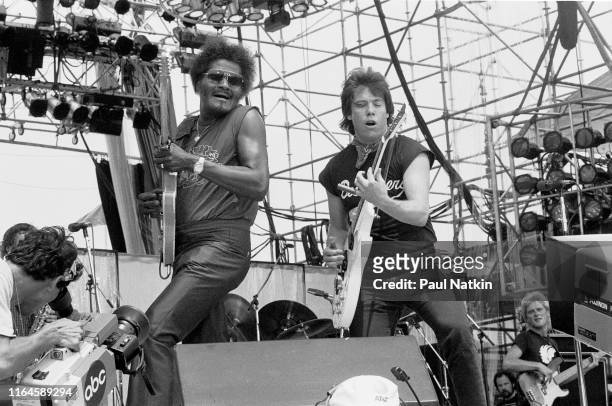 American Blues musicians Albert Collins and George Thorogood play guitars as they perform onstage during the Live Aid benefit concert at Veteran's...