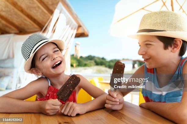 bruder und schwester essen eis am strand - boy and girl eating ice cream stock-fotos und bilder