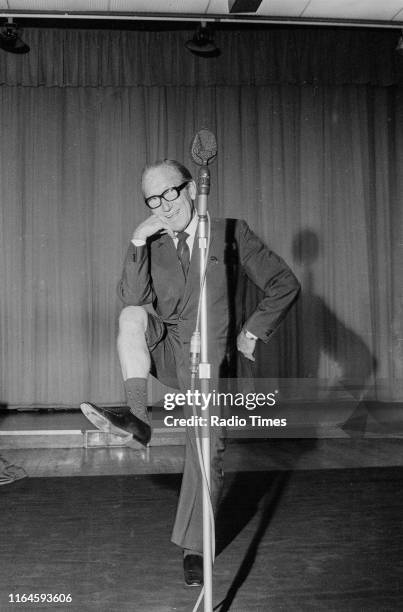 Comedian Arthur Askey joking around in front of a microphone during a recording for the BBC Radio 4 comedy series 'Does the Team Think?', September...