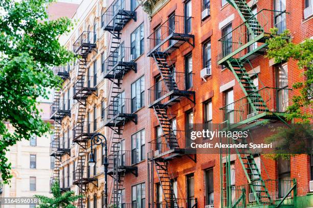 house facade with fire escape stairs in east village, manhattan, new york - greenwich village photos et images de collection