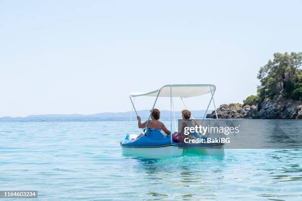 due donne senior che si rilassano su un pedalò al mare - pedal boat foto e immagini stock